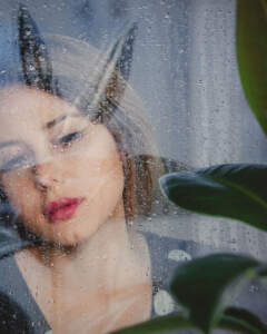 Sad girl in window.